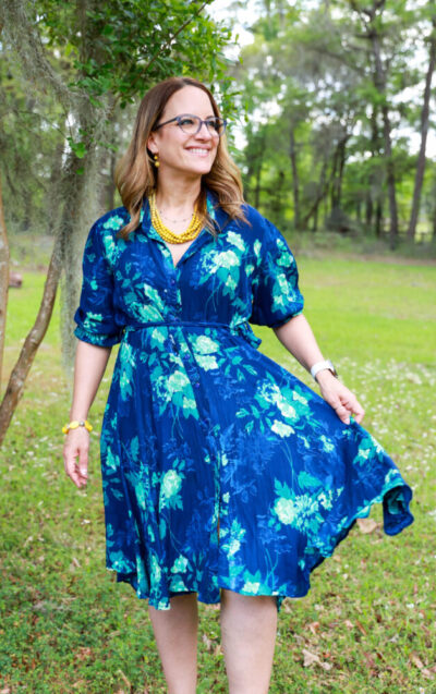 Portrait of Laura wearing a blue dress outdoors in a backyard garden