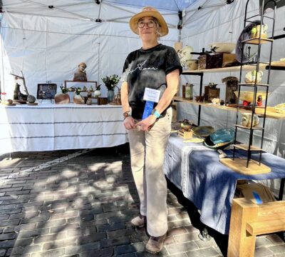 Veronica posing in front of her tent at the Downtown Art Festival 2025