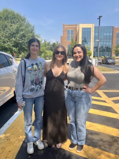 Madel posing with her two daughters smiling