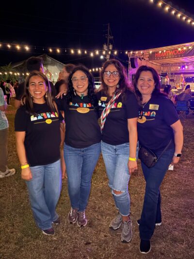 Four latina women posing at a concert wearing their film festival t-shirt