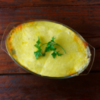 An oval dish with mashed potatoes and meat inside